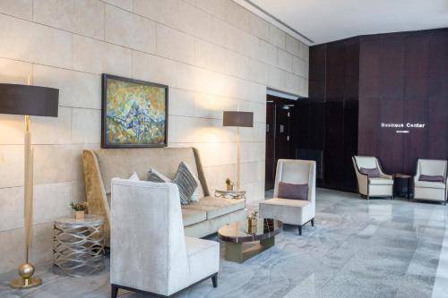 a lobby with a couch and two chairs at Signia by Hilton in Amman