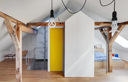 a room with a yellow wall and wooden beams at Design Apartments "Hier war Goethe nie" in Weimar
