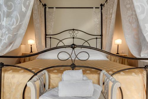 a bed with a black frame and white towels on it at Le Terre Di Isa in Magione