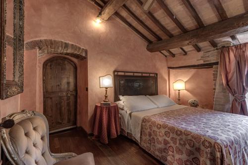 a bedroom with a bed and two lamps and a chair at Le Terre Di Isa in Magione