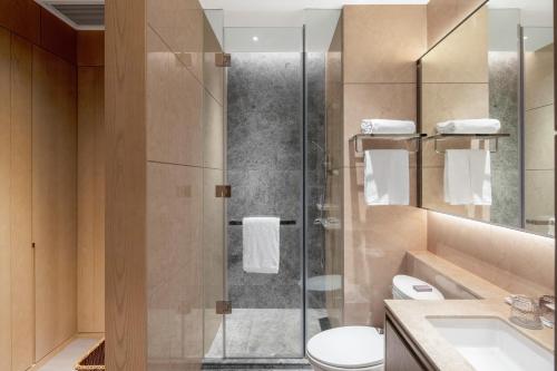 a bathroom with a shower with a toilet and a sink at Primcasa Chengdu in Chengdu