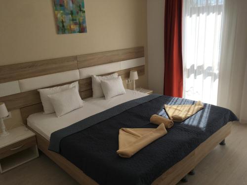 Un dormitorio con una cama grande con dos zapatos. en Hotel Pallone, en Balatonfüred