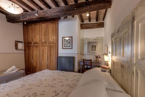 a bedroom with a bed and a wooden cabinet at Le Terre Di Isa in Magione
