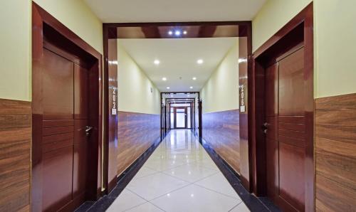 an empty hallway with wooden doors and wooden floors at Treebo Sky Point in Siliguri
