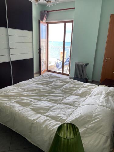 a bedroom with a large bed with a view of the ocean at Sea view apartment/beach/city center/WiFi in Durrës