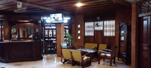 a dining room with a table and chairs and a television at Hotel Bifa Yogyakarta in Yogyakarta