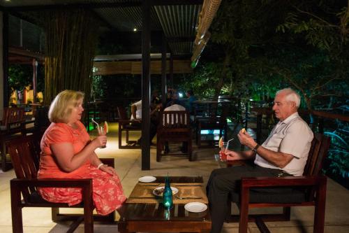 a man and a woman sitting in chairs drinking wine at Wet Water Airport Resort in Gampaha
