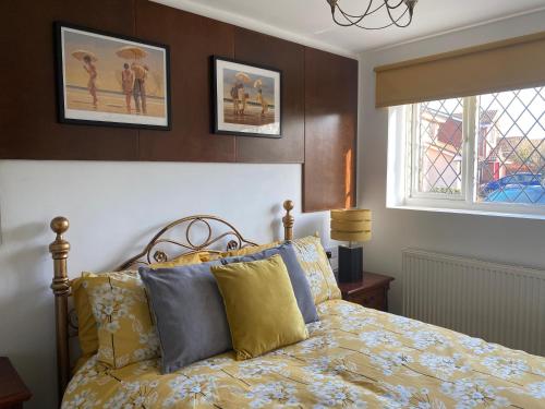 um quarto com uma cama com almofadas amarelas e azuis em The Daytona - Triumph Apartments Meriden NEC 6.5m em Meriden