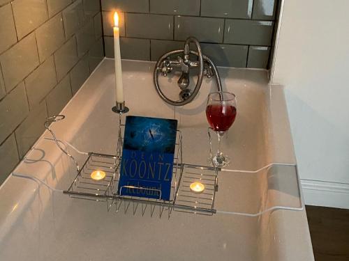 a candle and a book and a glass of wine at The Daytona - Triumph Apartments Meriden NEC 6.5m in Meriden