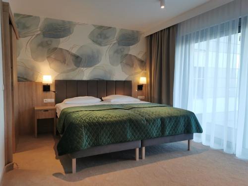 a bedroom with a bed and a large window at Hotel SKAL Medi SPA & Resort in Ustronie Morskie