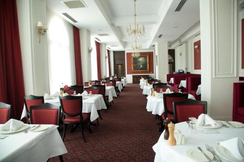 a dining room with white tables and red chairs at ANIM Boutique Hotel in Denizli