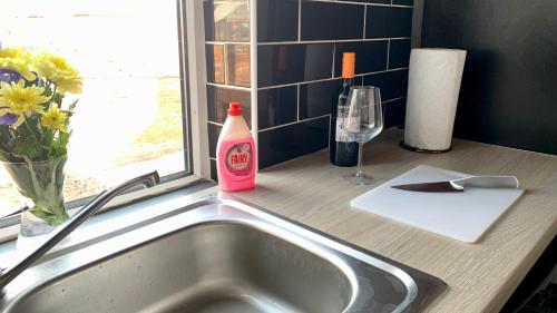 eine Küchentheke mit einer Spüle und einer Flasche Soda in der Unterkunft Apartment in City centre, 4 guests, CAR PARK in Doncaster