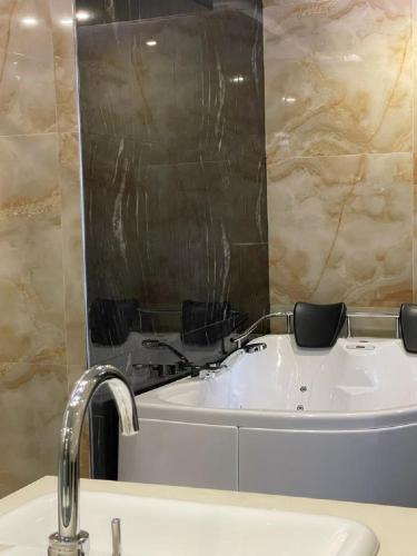 a bathroom with a tub and a sink with a mirror at شقق قولد ان للشقق المخدومة in Riyadh