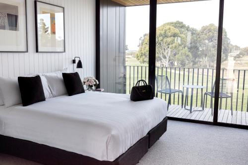 a bedroom with a large white bed and a balcony at Accommodation @ Curlewis in Curlewis
