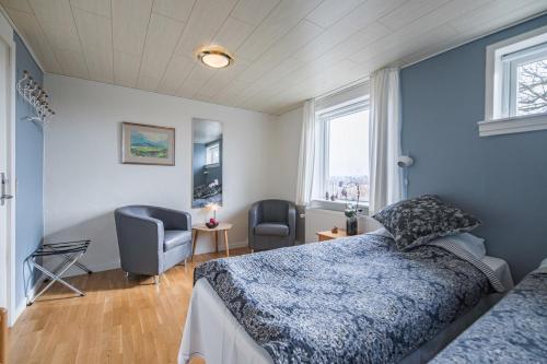 una camera con un letto e una sedia e una finestra di Hotel Højgaarden a Slettestrand