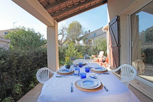 une table avec un tissu de table blanc sur une terrasse dans l'établissement Kazamasavani - Belle maison proche mer, à Cervione