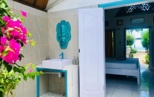 Pelangi Cottages Gili Air في غيلي آير: حمام مع حوض وحوض استحمام