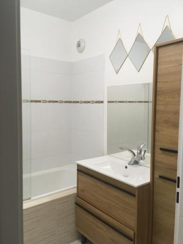een badkamer met een wastafel en een bad bij Appartement situé place toscane à 5 min de disney in Serris