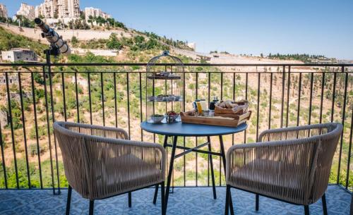 Una mesa y dos sillas en un balcón. en Lifta Boutique Hotel & Spa, en Jerusalén
