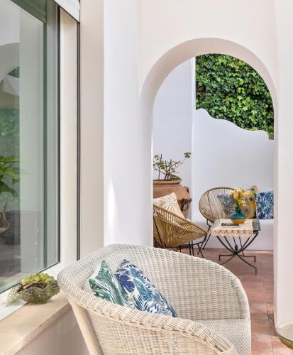 a porch with a wicker chair and a table at B&B Il Sogno in Anacapri