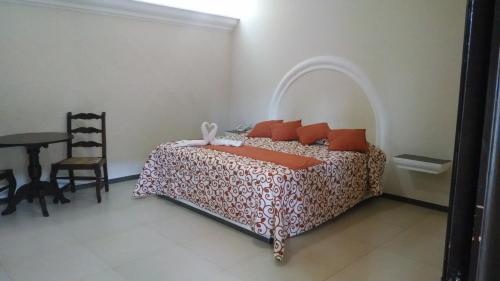 a bedroom with a bed and a table and a chair at Hotel Plaza Hidalgo in Ixtlán del Río