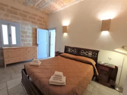 una camera da letto con un grande letto con asciugamani di Bed & Breakfast Casa Lopez a Barletta