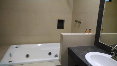 a bathroom with a white tub and a sink at Hotel Plaza Hidalgo in Ixtlán del Río