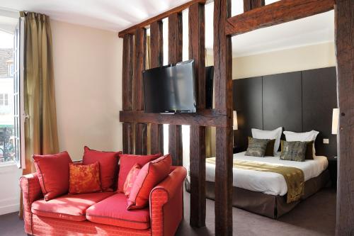 1 dormitorio con 1 cama y 1 sofá con TV en Le Saint-Jacques, en Cloyes-sur-le-Loir