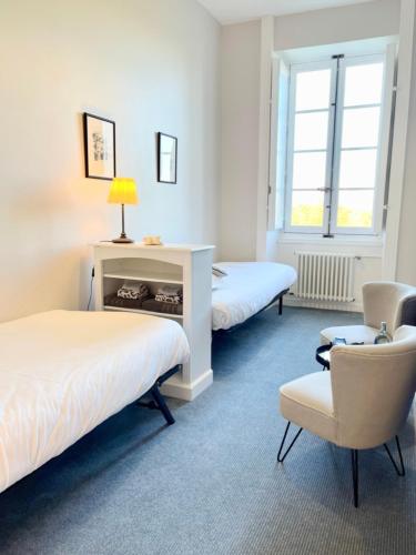 une chambre d'hôtel avec deux lits et une chaise dans l'établissement Domaine du Plessis Grimaud, à Saint-Viaud