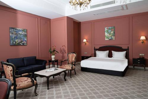 a hotel room with a bed and a couch and chairs at ANIM Boutique Hotel in Denizli