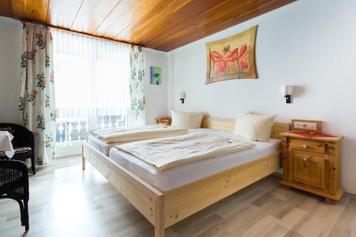 a large bed in a room with a large window at Genusshotel Gersbacher Hof in Todtmoos