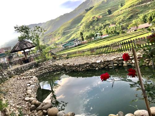 ein Wasserbad mit roten Rosen vor einem Hügel in der Unterkunft Ta Van Family Homestay in Sa Pa