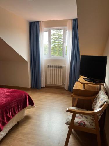 a bedroom with a bed and a desk with a computer at Villa De Llanes in Llanes