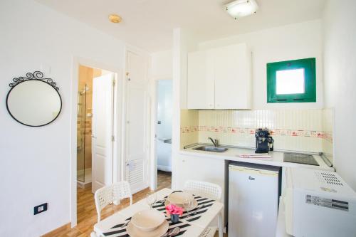 una cucina con mobili bianchi, tavolo e sedie di Moya a Tías