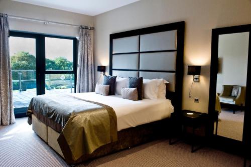 a bedroom with a large bed and a large window at The Lodge at Kingswood in Epsom