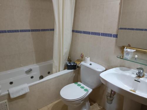 a bathroom with a toilet and a sink at Hosteria Real de Zamora in Zamora