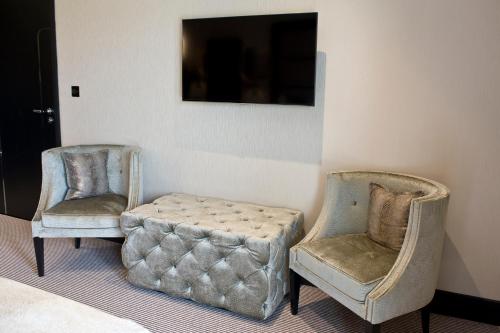 two chairs and a ottoman in a room at The Lodge at Kingswood in Epsom