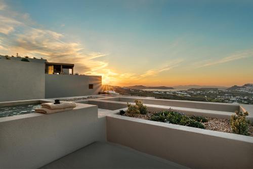 a sunset from the balcony of a house at North Santorini - A Luxury Spa Hotel in Pirgos