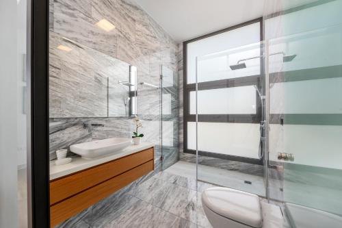 a bathroom with a sink and a glass shower at Villa Laurus 2 with private pool in Paphos