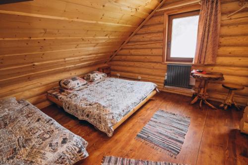 sypialnia z 2 łóżkami w drewnianym domku w obiekcie Садиба Віват w mieście Orawczyk