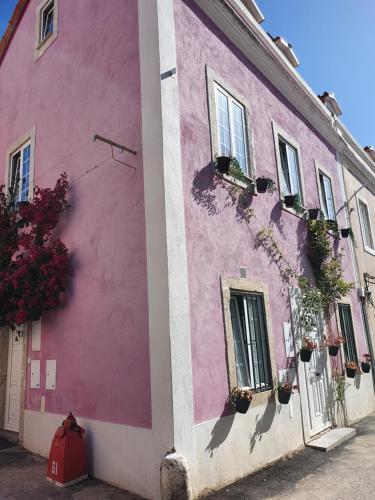 un edificio rosa con ventanas y flores. en Casa Cor de Rosa en Lisboa