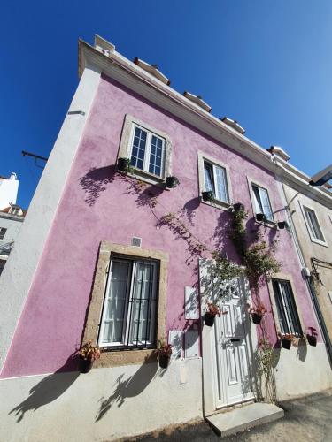różowy budynek z oknami i kwiatami w obiekcie Casa Cor de Rosa w Lizbonie