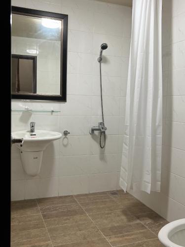 a bathroom with a shower and a sink and a toilet at Dou Dou Long Homestay in Donggang