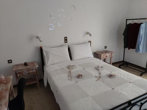 a bedroom with a bed with white sheets and two tables at Gioula's Residence in Patitiri