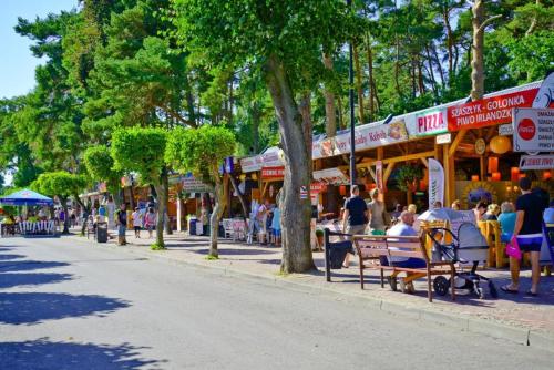 Un groupe de personnes assises sur des bancs dans une rue urbaine dans l'établissement Apartament Pinea 410 Pobierowo, à Pobierowo