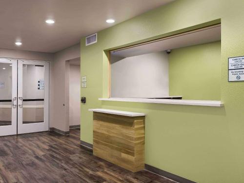 a waiting room with a large mirror on a green wall at WoodSpring Suites Cedar Park - Austin North in Cedar Park