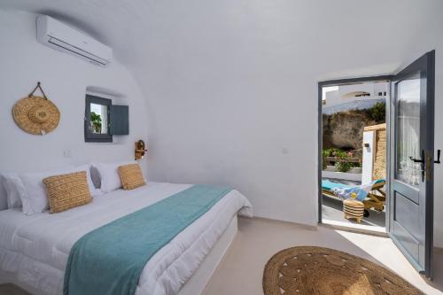 um quarto branco com uma cama e uma varanda em Mystagoge Retreat with subterranean pool/jacuzzi em Vóthon