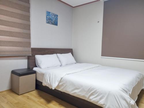 a bedroom with two beds and a window at Charlie Hotel Jeju in Jeju