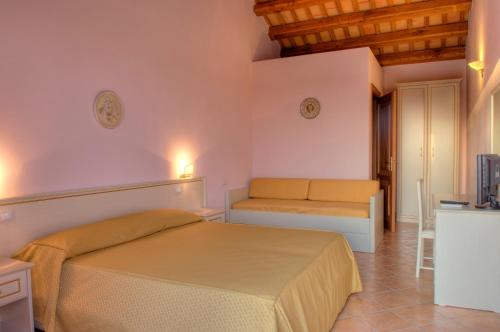 - une chambre avec un lit, un canapé et une télévision dans l'établissement Baglio Antico, à Fulgatore