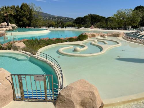 une grande piscine avec toboggan dans un parc aquatique dans l'établissement Les Restanques - Grimaud, à Grimaud